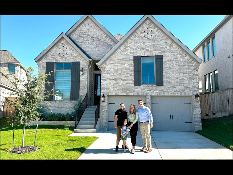 Happy homeowners in front of their new home